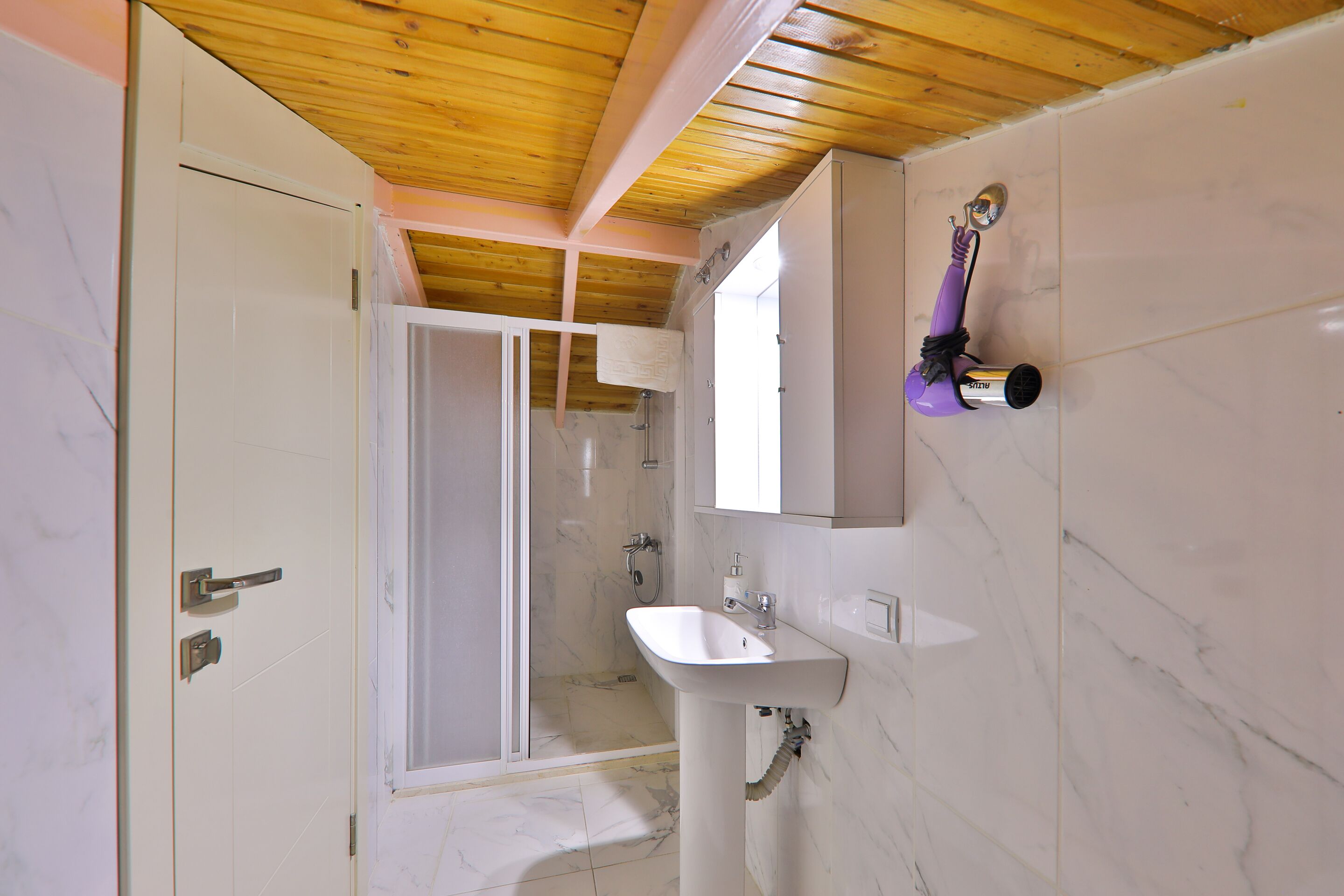 A bathroom with a shower, a sink, and a mirror.