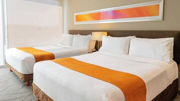A hotel room with two beds, a large window, and a painting on the wall.