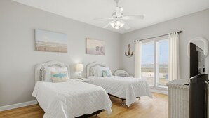 A bedroom with two beds, a ceiling fan, artwork on the walls, and a window with curtains. - Directly Across from Gulf with Views from Every Balcony! The Easiest Access! (Navarre)