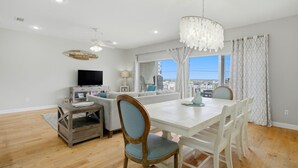 A dining area with a white table, chairs, and a chandelier. - Directly Across from Gulf with Views from Every Balcony! The Easiest Access! (Navarre)