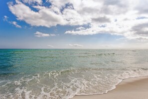 A beach with clear turquoise water and a sandy shore under a partly cloudy sky. - Directly Across from Gulf with Views from Every Balcony! The Easiest Access! (Navarre)
