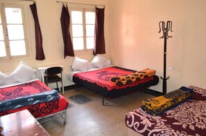 A room with two beds, a desk, and a chair.