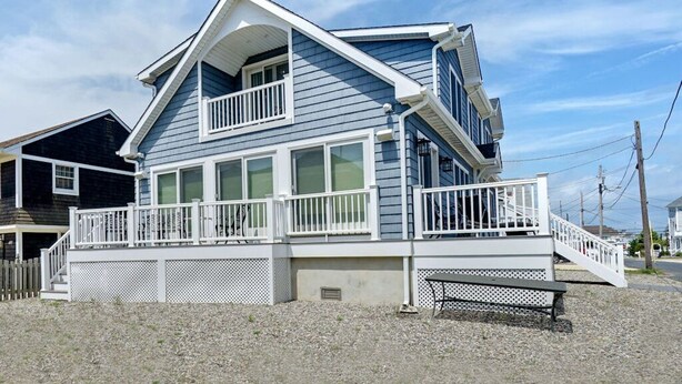 A two-story house with a balcony and a covered porch area. - Deauville Beach Ocean-side Property (Mantoloking)