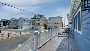 A residential area with a wooden deck and a white railing. - Deauville Beach Ocean-side Property (Mantoloking)