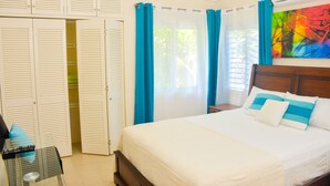 Un dormitorio con cama, armario y un cuadro en la pared.