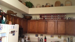 A kitchen with wooden cabinets, a refrigerator, and various kitchen appliances. - Cool Summers + Warm Winters on 18 Hole Golf Course (Escondido)