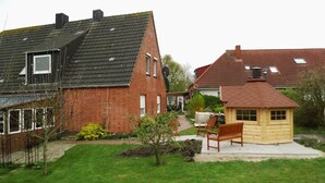 A residential area with brick houses, a wooden playhouse, and a well-maintained lawn. - Apartment at the old Greetsieler Tief (Eilsum)