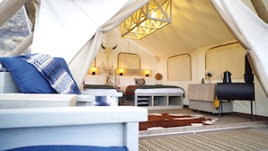 A cozy tent with a bed, a sofa, and a grill. - Black Tree Resort (Lake George)
