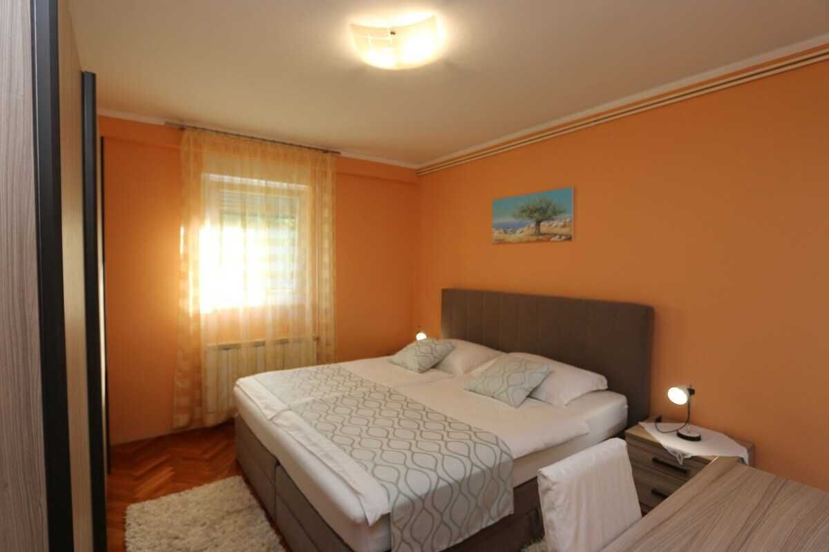 Una camera da letto con un letto, un comodino e un quadro appeso al muro.