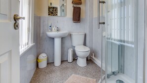 A bathroom with a sink, toilet, and glass shower enclosure. - Hawthorn House (Blackpool)
