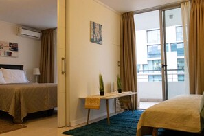 Departamento Deluxe, vista a la ciudad | Sala de estar | Televisión LED de 32 pulgadas con canales por cable y televisión 