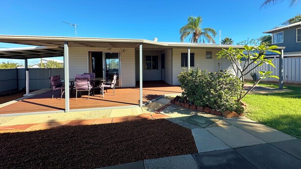 A covered patio with outdoor furniture, a small garden, and a house in the background. - The Secret Waypoint - Kalbarri, WA (Kalbarri)