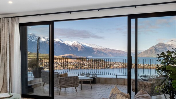 Ein geräumiger Balkon mit Blick auf eine gebirgige Landschaft und einen See.