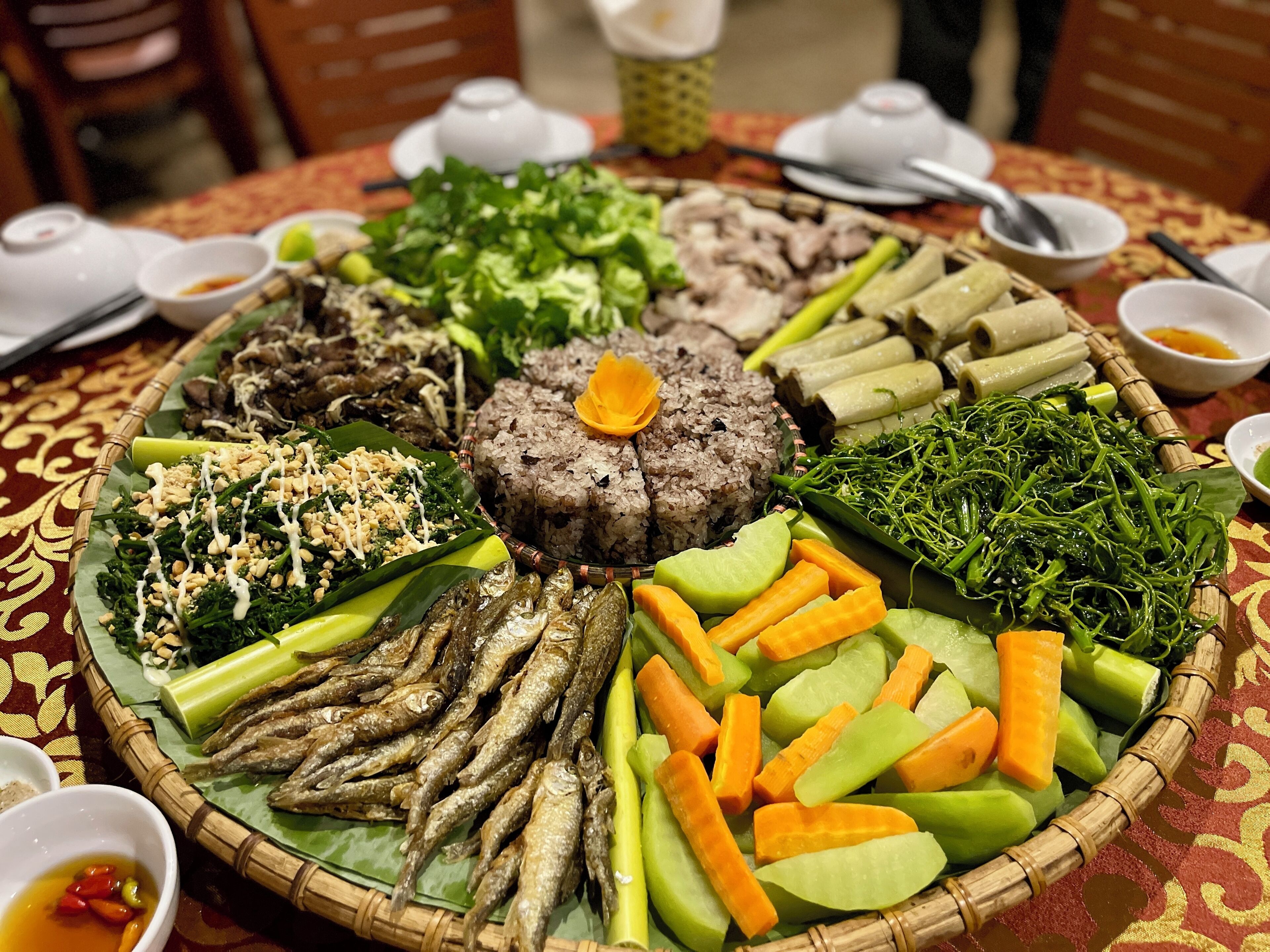 A traditional meal with various dishes arranged on a table.