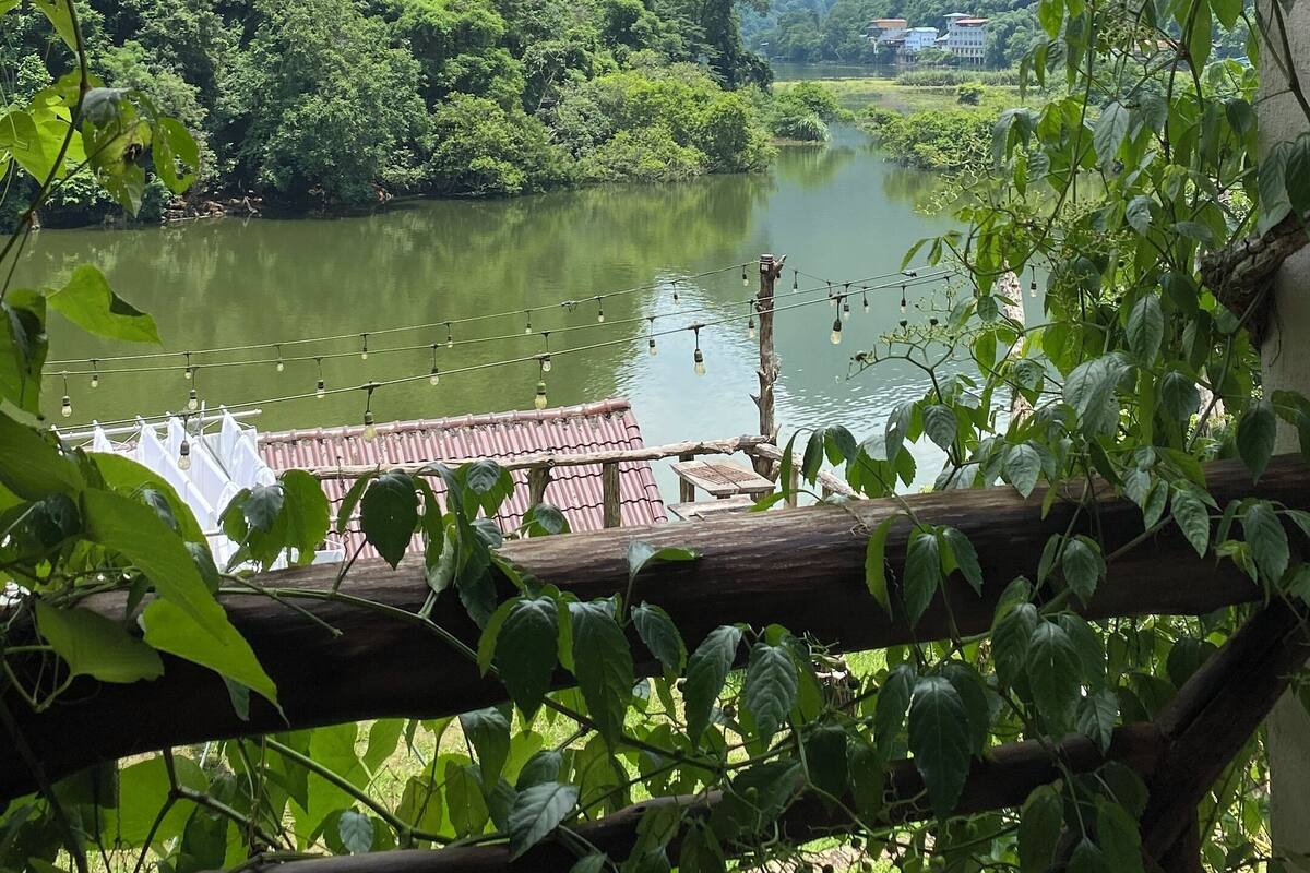 Vista de un río con un muelle de madera y un edificio al fondo.