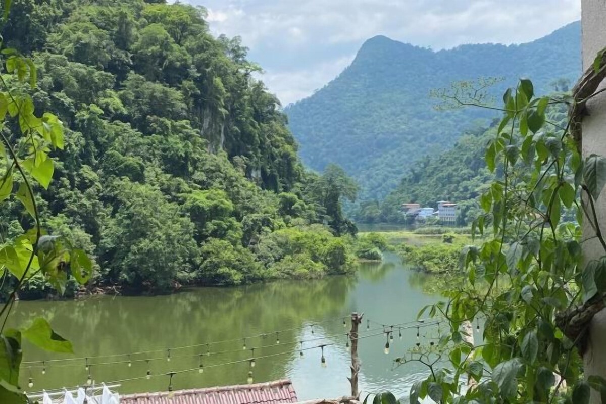 A view of a river with lush greenery and hills in the background.
