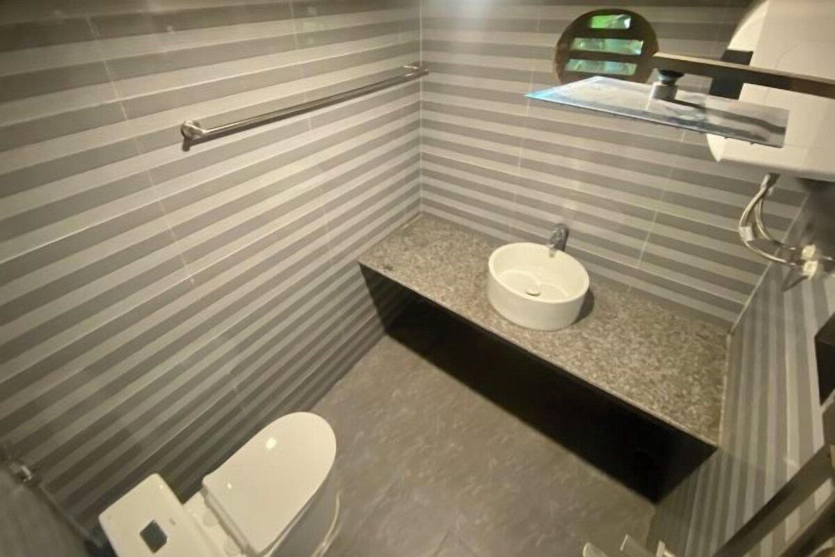 A bathroom with striped walls, a white sink, and a toilet.