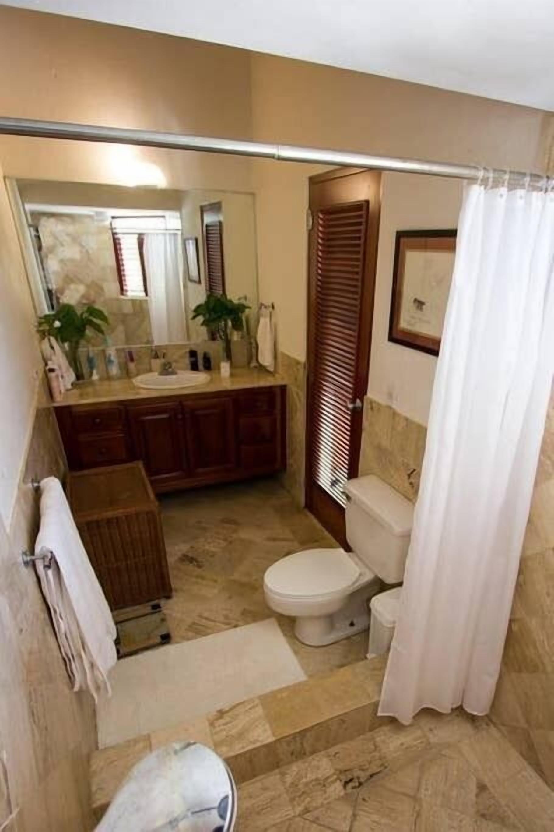 A compact bathroom with a toilet, sink, and vanity.