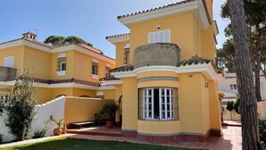 A yellow building with a curved balcony and a window with bars. - Spacious holiday home by the sea (Chiclana de la Frontera)