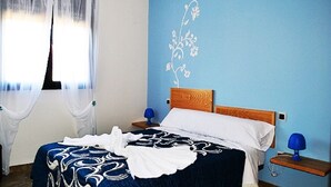 A bedroom with a bed, a nightstand, a lamp, and a window with sheer curtains. - Lodging AT-CC-00296,Extremadura,garden,private garage,air conditioning, hydromassage, air conditioning, heating, air conditioner, heating, air conditioner, heating, air conditioner, heating (Zarza de Granadilla)