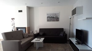 A modern living room with a sofa, coffee table, and a flat-screen TV. - Lodging AT-CC-00296,Extremadura,garden,private garage,air conditioning, hydromassage, air conditioning, heating, air conditioner, heating, air conditioner, heating, air conditioner, heating (Zarza de Granadilla)