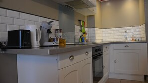 Een keuken met witte kastjes, een koffiezetapparaat, een broodrooster en een vaatwasser.