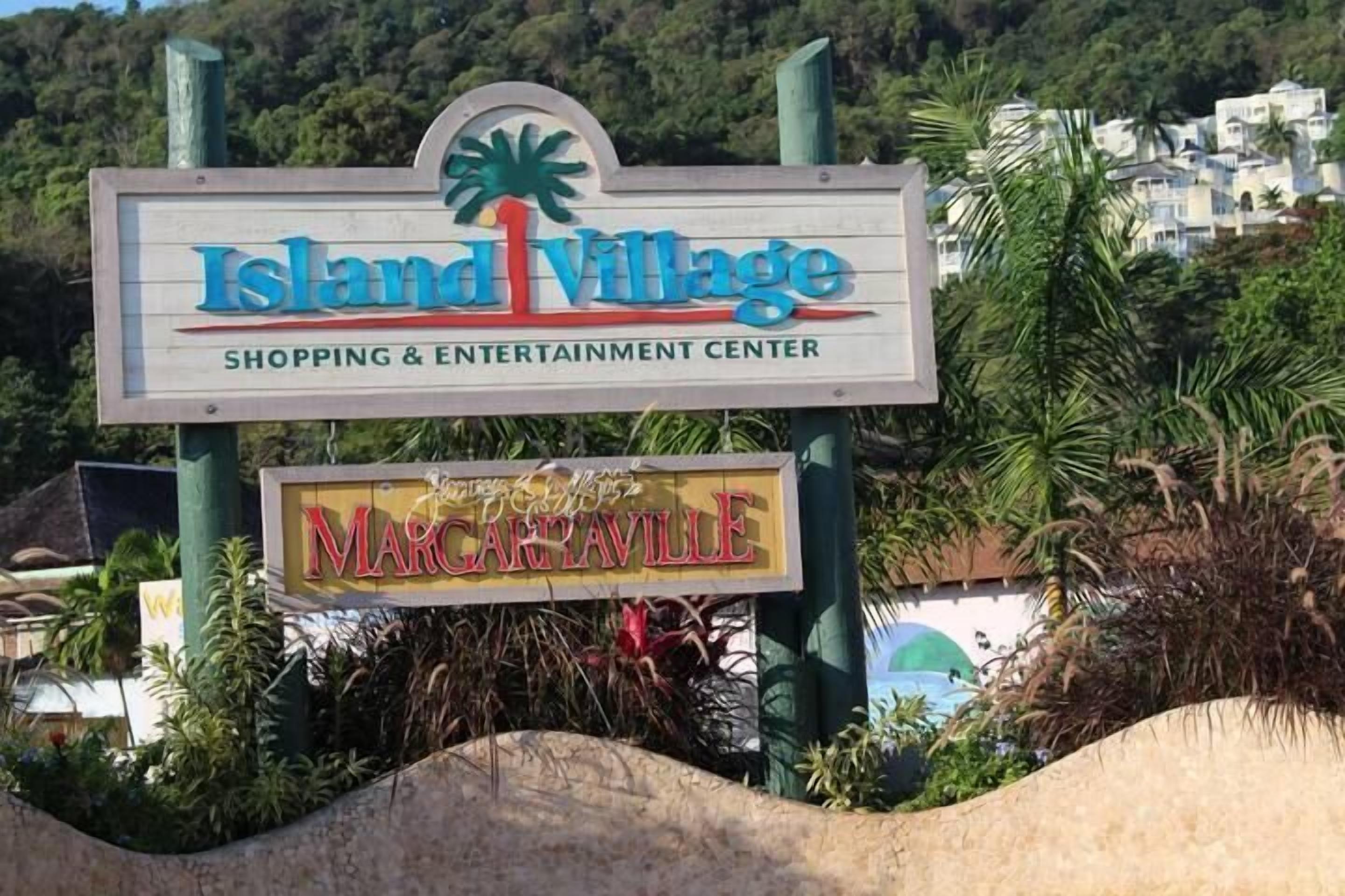A sign for Island Village Shopping & Entertainment Center with a palm tree logo.
