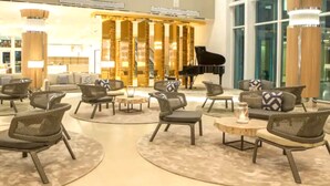 A spacious lobby with a grand piano, comfortable seating areas, and a modern interior design. - Best of Bimini - Oceanview - 2 Bedroom / 2 Bath (Bimini)