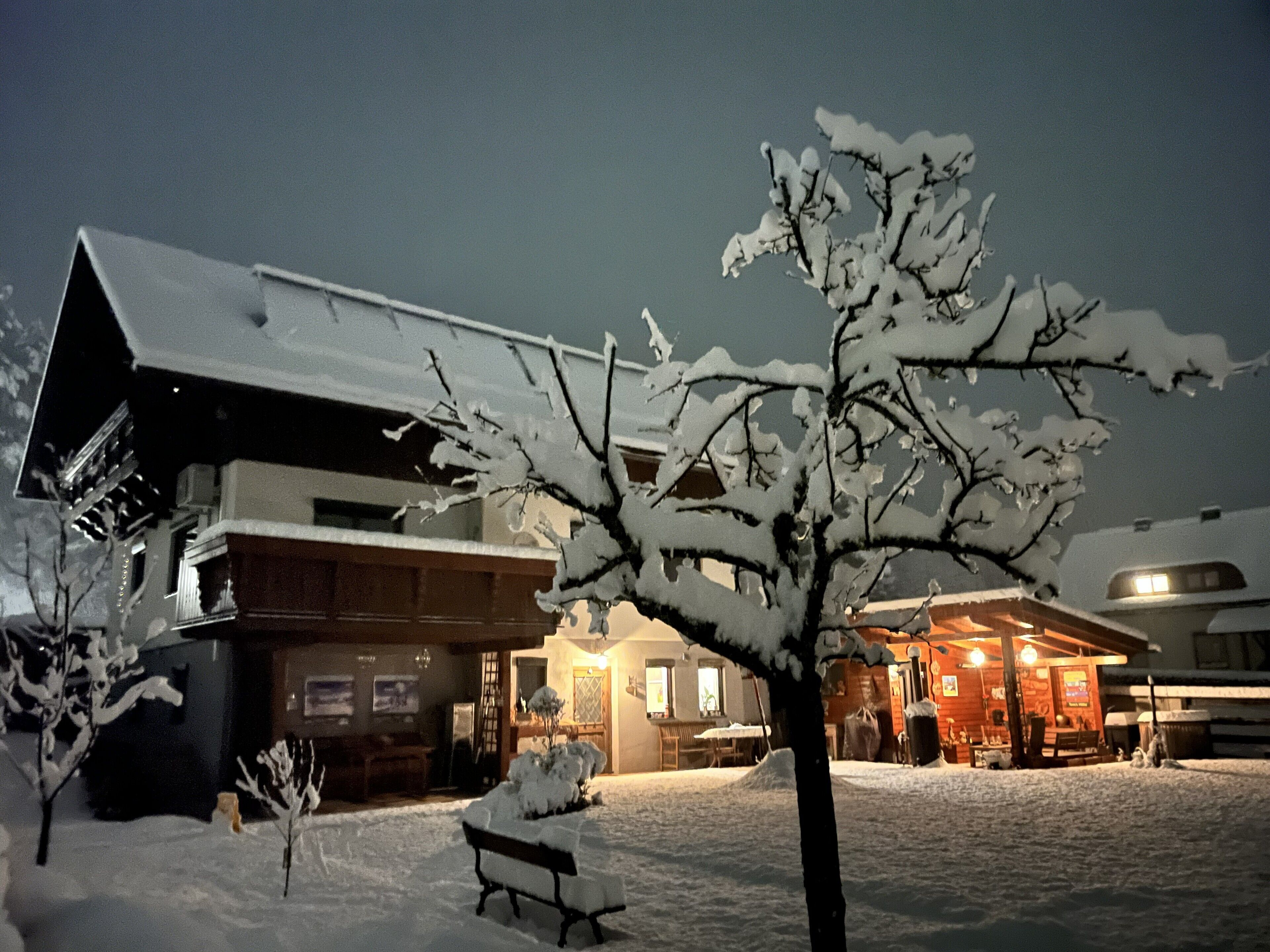 A snow-covered building with a wooden exterior and a visible entrance.