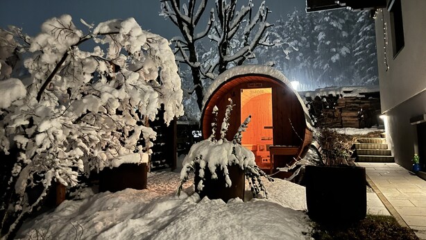 Un área al aire libre cubierta de nieve con una estructura de madera identificada como "EXPOE" y un árbol nevado.