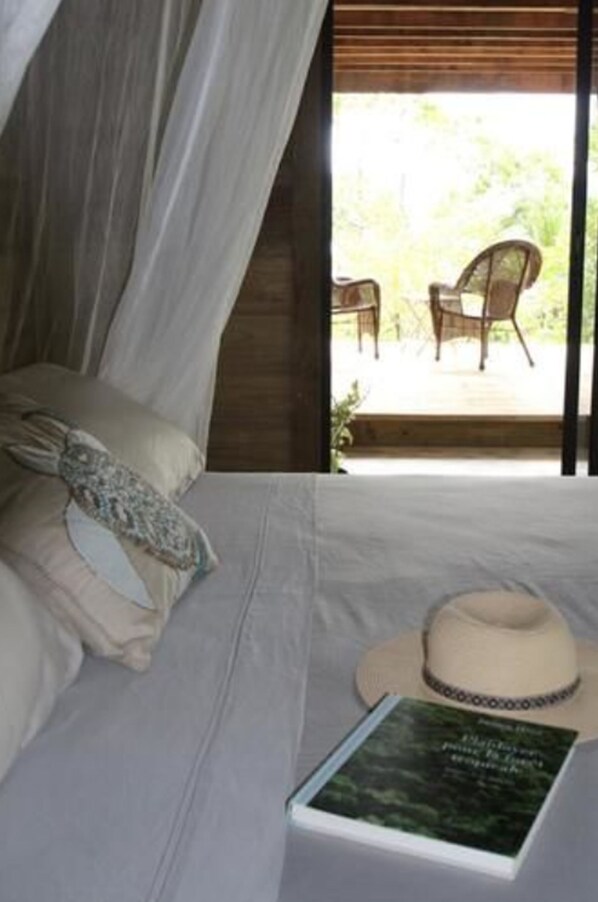 Un dormitorio con una cama, un libro y un sombrero sobre la cama.