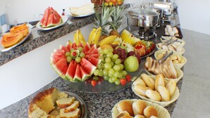 A buffet table with various fruits, bread, and other food items. - Hotel Abrolhos (Nova Viçosa)