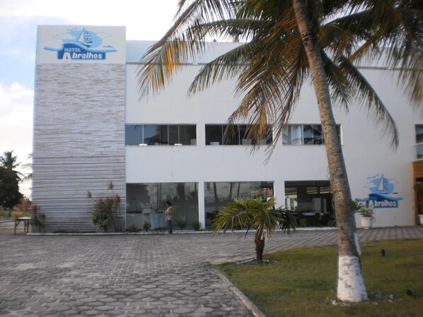 A modern building with a logo of a sailboat and the name 'Hotel Abrolhos'. - Hotel Abrolhos (Nova Viçosa)