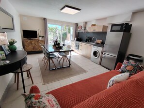 A modern kitchen with a dining area, a washing machine, and a refrigerator.