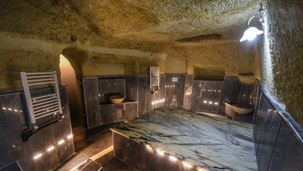A modern bathroom with a marble countertop, built-in shelves, and a towel rack. - Rose Nest Cave Otel (Ürgüp)