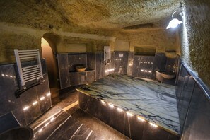 A modern bathroom with a marble countertop, built-in shelves, and a towel rack. - Rose Nest Cave Otel (Ürgüp)