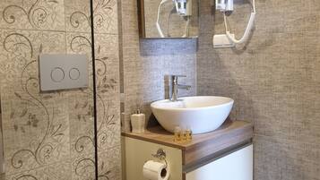 A modern bathroom with a toilet, sink, and mirror.