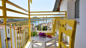 A balcony with yellow railings, a white table, and a yellow chair. - Limon Pansiyon (Kas)