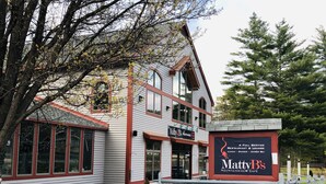 Een gebouw met twee verdiepingen, met een bord voor Matty's Mountainside Café, inclusief een restaurant en lounge.