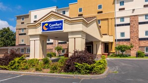A hotel with a prominent Comfort Inn & Suites sign, featuring a modern architectural design with beige and brown tones, and a landscaped entrance area. - Comfort Inn & Suites Michigan City South (Michigan City)