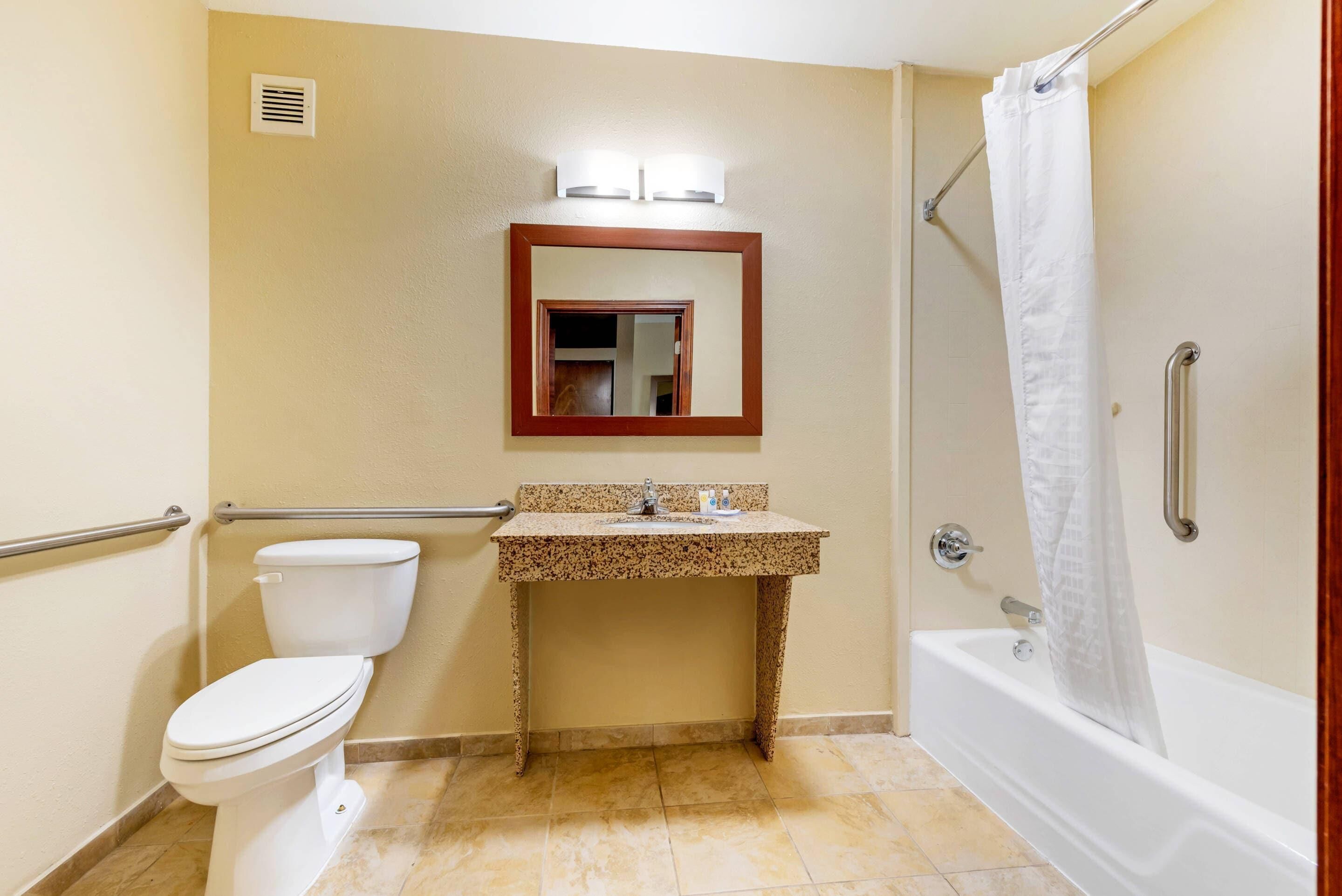 A bathroom with a toilet, sink, and bathtub.