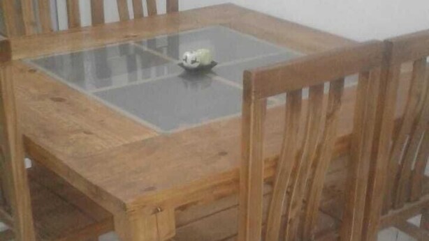 A wooden dining table with a glass top and six chairs. - Zona Peatonal Central Apartment Mendoza City (Mendoza)