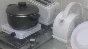 A kitchen with a stove, a toaster, a kettle, and a pot on the counter. - Zona Peatonal Central Apartment Mendoza City (Mendoza)