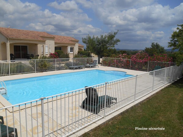 Relax by the pool surrounded by lush greenery and comfortable lounge seating.