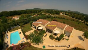 Escape to Clos de Cougoussat, surrounded by lush greenery and rolling hills, with a swimming pool.