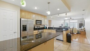 A modern kitchen with granite countertops, stainless steel appliances, and wooden cabinets. - Rivers Edge Condo #1A, Bldg 2- PRIVATE DOCK with ASSIGNED BOAT SLIP (Steinhatchee)