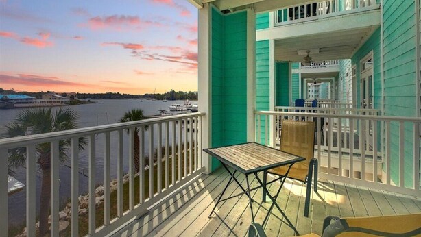A balcony with a view of a river, a table, and chairs. - Rivers Edge Condo #1A, Bldg 2- PRIVATE DOCK with ASSIGNED BOAT SLIP (Steinhatchee)