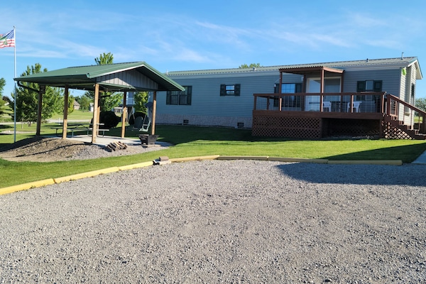 Front of the house. Gazebo has a picnic table, fan and a swing. Firepit also.