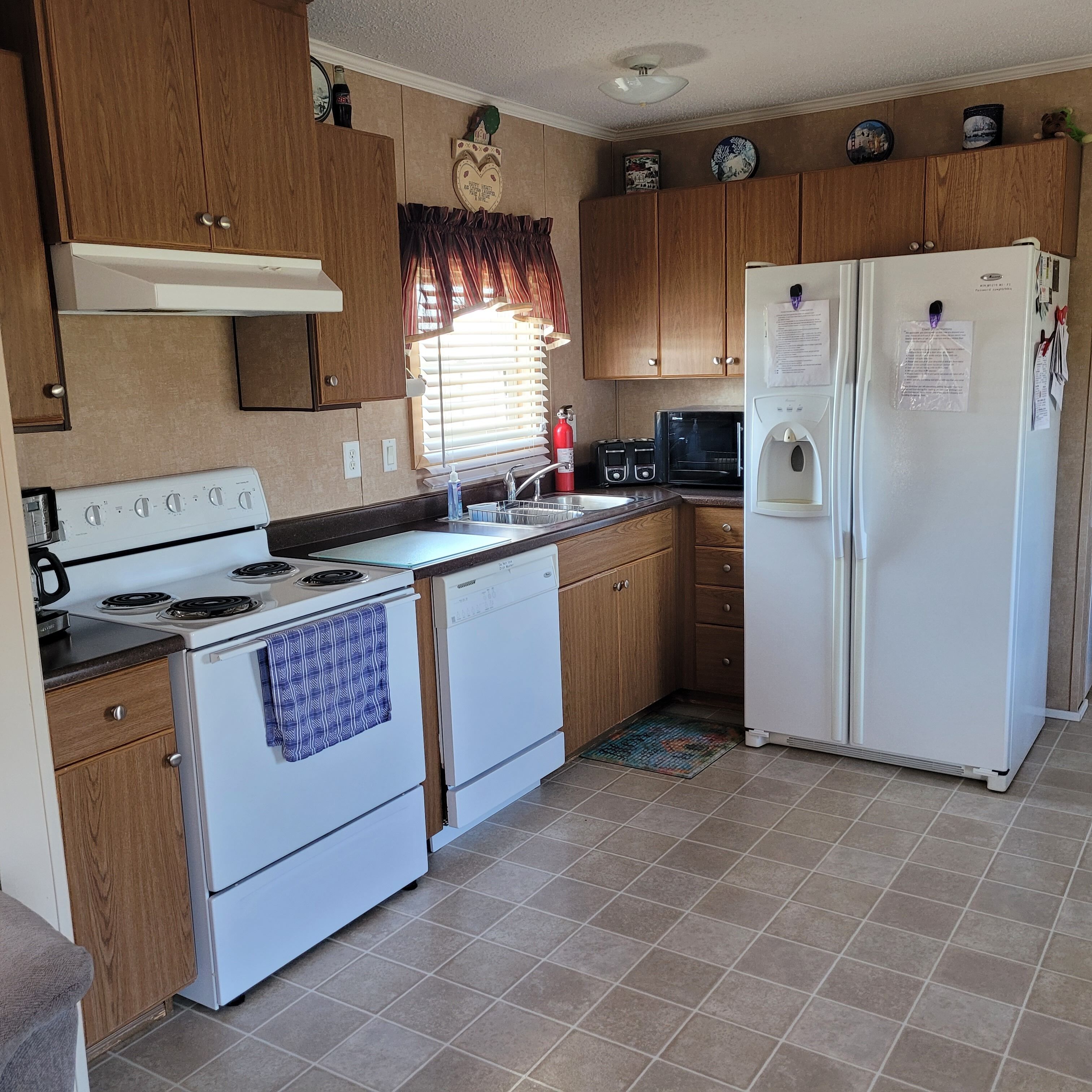 A compact kitchen with a stove, oven, microwave, and refrigerator.