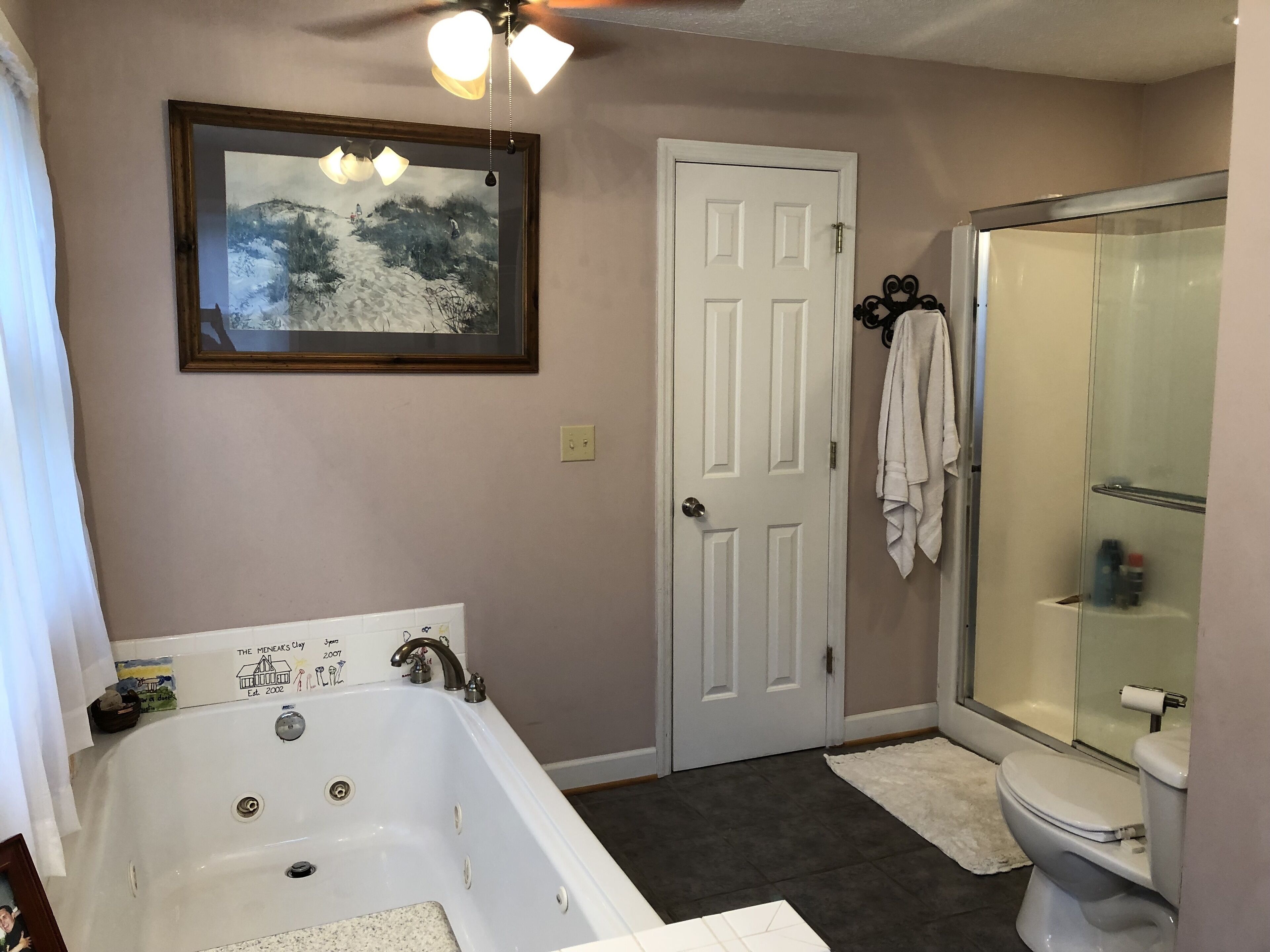 A bathroom with a bathtub, toilet, and glass shower enclosure.